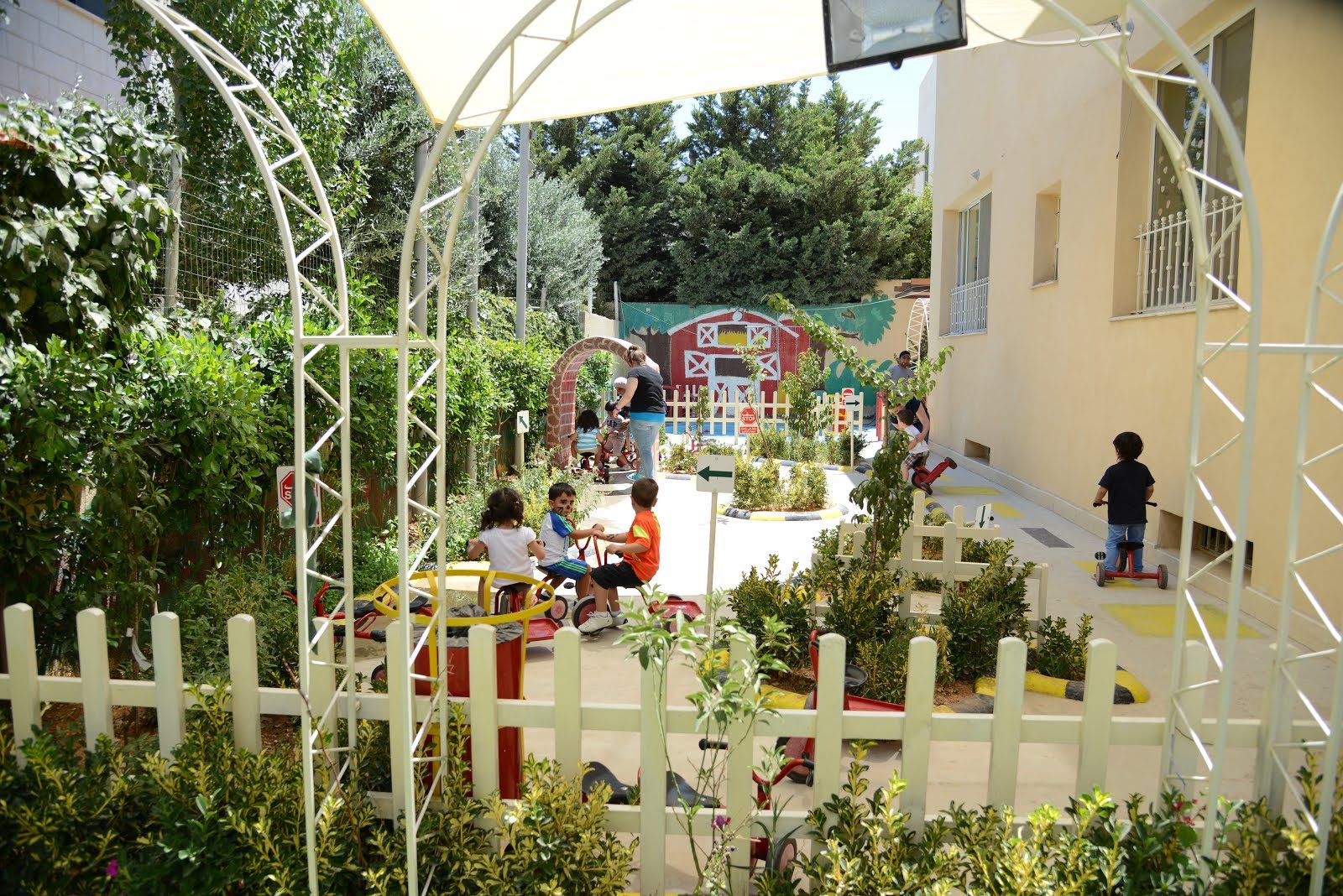 Children riding tricycles through the outdoor traffic-land garden